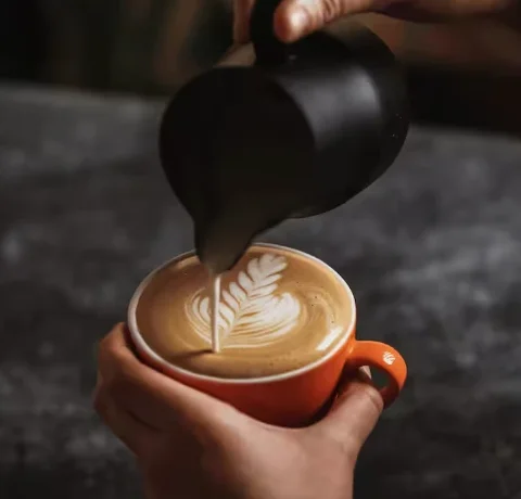 Latte art en taza naranja